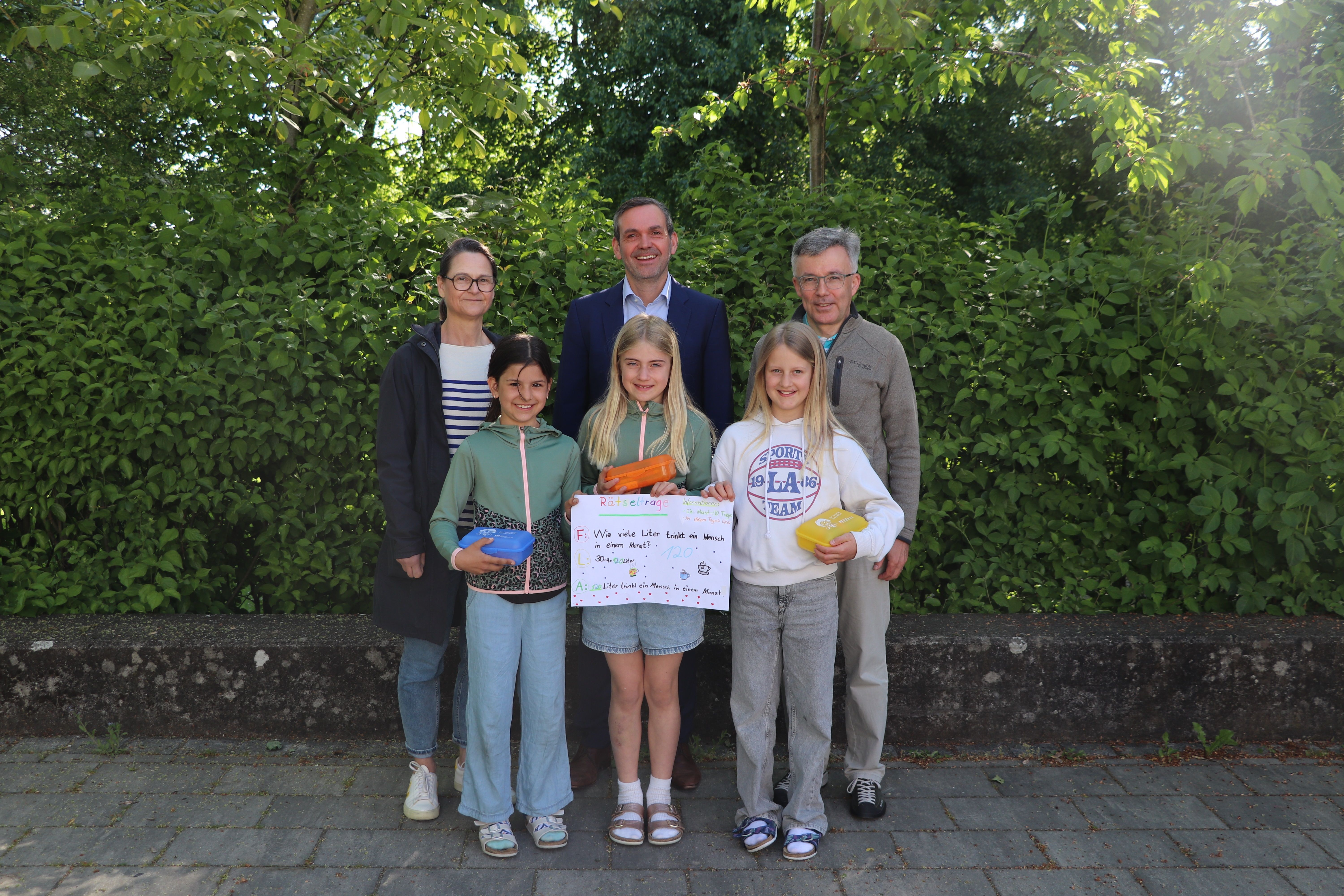 Miriam Anzenhofer, Amelie Weishaupt, Annalena Hartmann sowie (hinten): Herrn Andreas Speinle von der VR-Bank Donau-Mindel e.G. (Mitte), die Klassenleiterin Frau Susanne Hofmann (3b) sowie Herrn Rektor Stephan Wolk